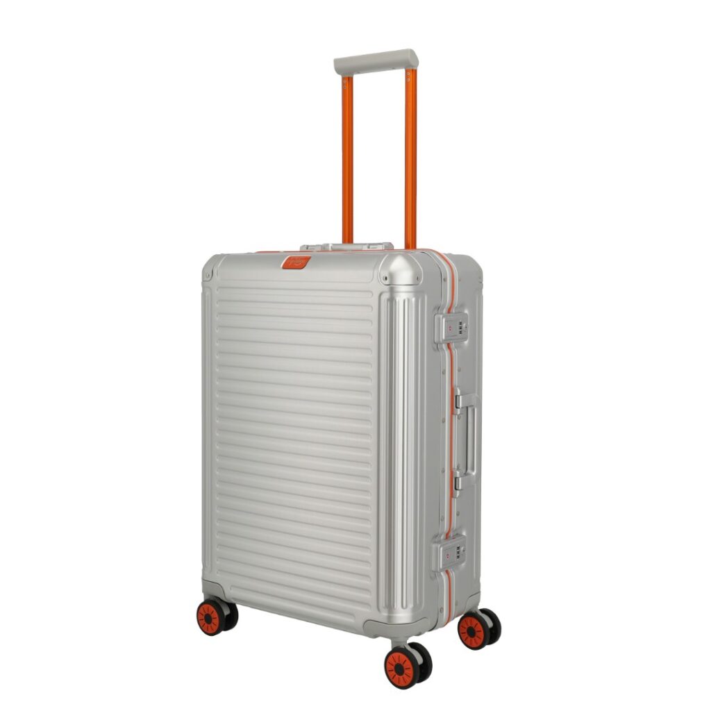 AB INS ABENTEUER Travelite Next Trolley mit knalligen orangefarbenen Akzenten – 75 Jahre Jubiläumskollektion. Limited Edition, silbernes Aluminium, flexible Innenaufteilung und individuelle Seriennummer. LEDERWAREN VOEGELS